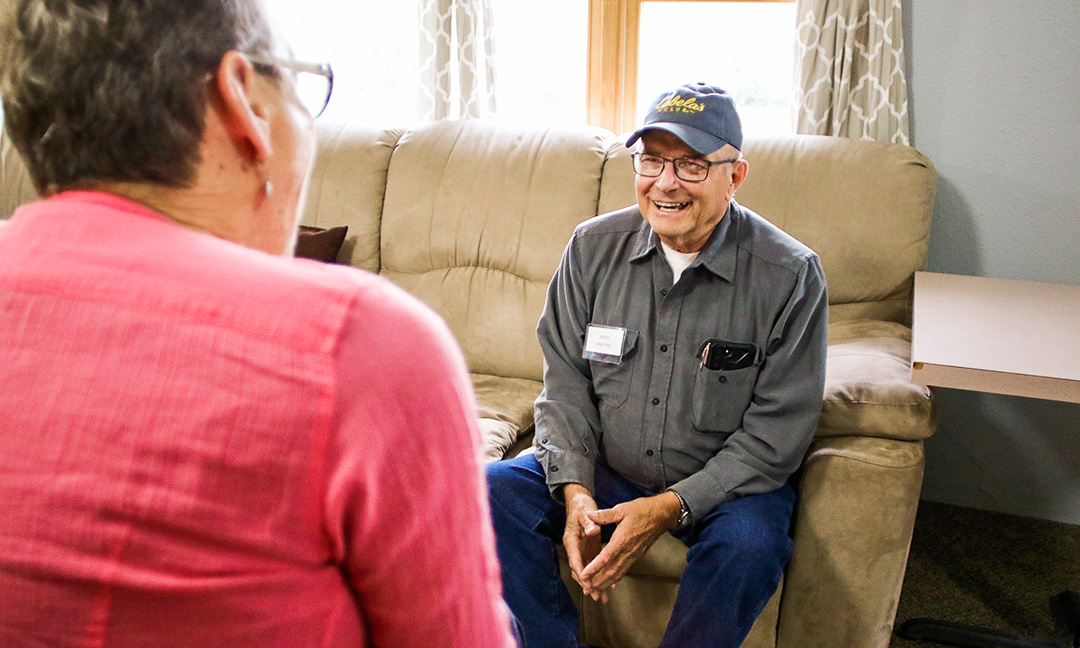 A man sitting on a sofa talking to a woman in Chadron