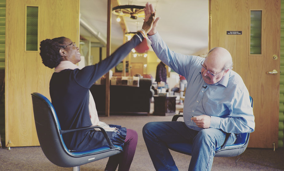 Seated woman and man high-fiving