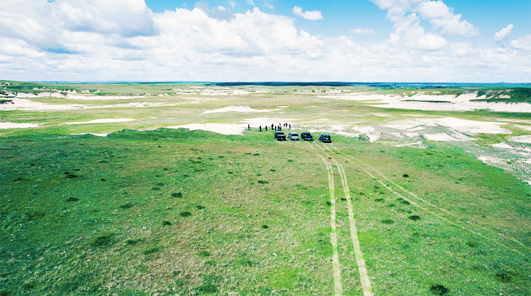 An overhead photo of the countryside at Chadron, NE with a group of cars and people.