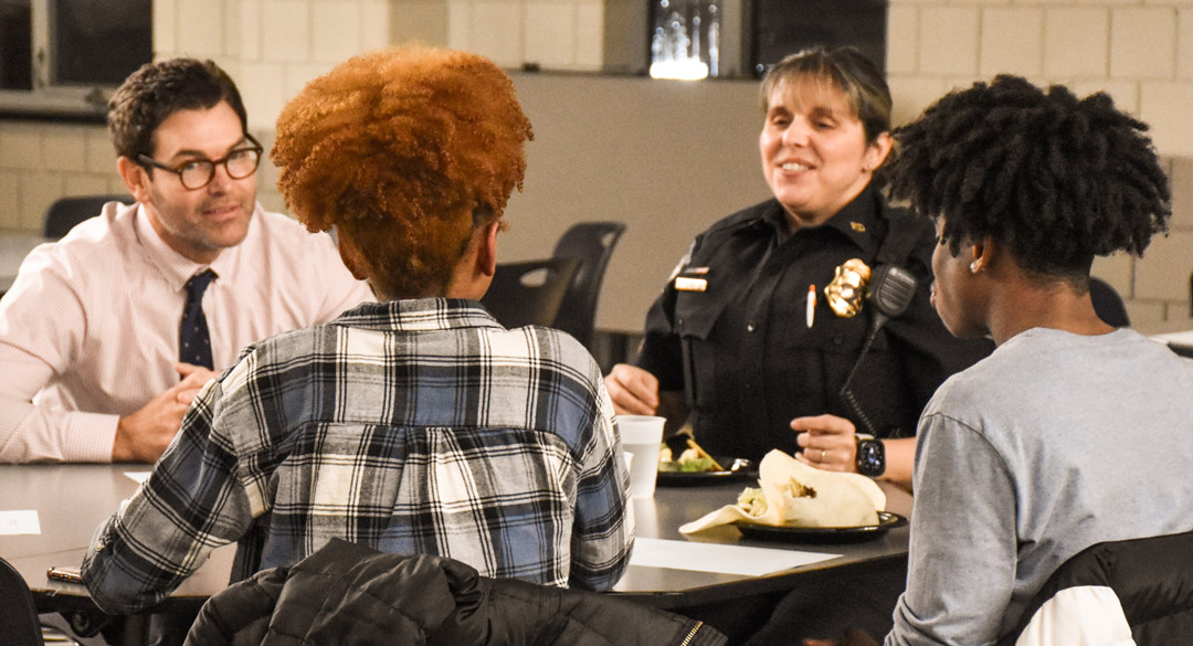 Four people in North Penn discussing in a circle over food