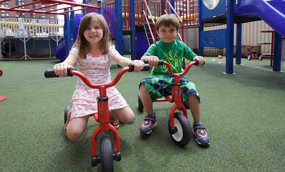 girl and boy riding tricycles